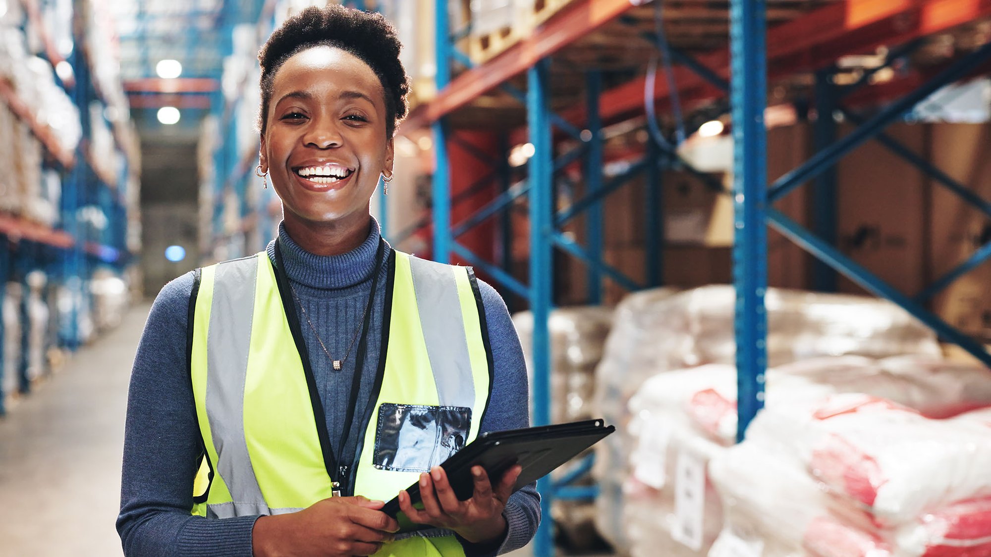 smiling female warehouse worker with a tablet